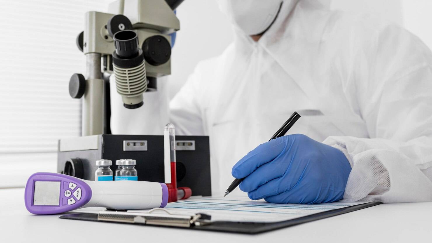 Biocheck Diagnostics And Polyclinic Blogs - A senior MD Pathologist at Biocheck Diagnostics manually reviewing a blood smear under a microscope to confirm laboratory results.